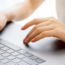 image of a women's hand while typing on the laptop